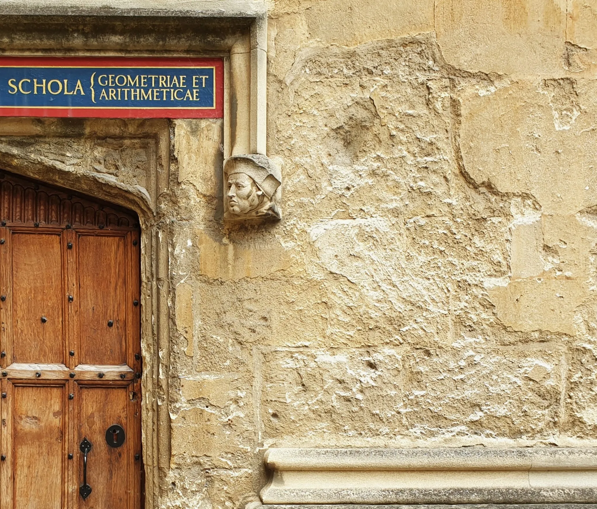 A door in Schools Quadrangle, Bodleian Library, Oxford, reading 'SCHOLA GEOMETRIA ET ARITHMETICAE'.